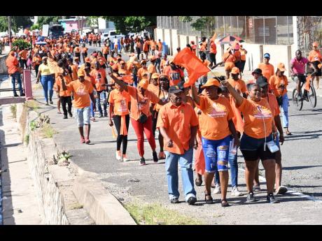 PNP supporters march with PNP councillors Louise Newland, for the Admiral Town division, along Collie Smith Drive in St Anderw, to the polling station at the Trench Town Community Development Centre yesterday.