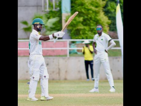 Jamaica Scorpions wicket-keeper batsman Romaine Morris raises his bat after scoring a half-century against the Windward Islands Volcanoes during their West Indies Championship encounter at Sabina Park yesterday.