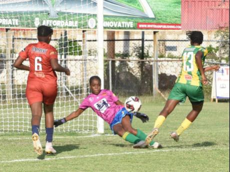 St Andrew Technical’s (STATHS) goalkeeper Rhianna Williams (centre) blocks a shot from Andrene Smith (right) of Excelsior High during yesterday’s ISSA TIP Friendly Schoolgirls football match at the Anthony Spaulding Sports Complex. Watching the action 