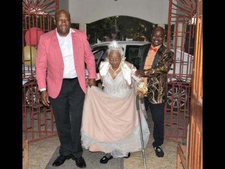 Alberta ‘Miss Berta’ Campbell-Malcolm, of Grange Hill, Westmoreland, is escorted by grandsons Shawn Spence (left) and Glenville Daley into the Shaun Lavery Faith Hall, where her 100th birthday party was held. 