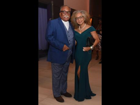 Attorney-at-law Courtney Hamilton (left) and wife, Judith Farmer, put their best foot foward, Hamilton in a checkered suit with navy jacket and Farmer in a swetheart neckline, green gown.