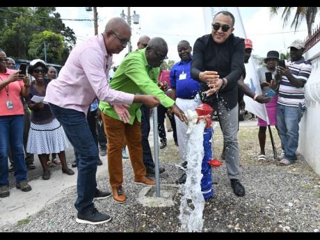 Local Government Minister Desmond McKenzie (centre) flanked by Norman Scott (right),  chairman of the St Catherine Municipal Corporation, and Dr Christopher Tufton, member of parliament for St Catherine West Central, when they turned on the water in Water