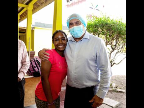 Christopher Zacca, chairman of the Sagicor Foundation, embraces 14-year-old Rickayla Miller during his tour of the Bustamante Children’s Hospital for Chldren’s Cardiac Centre.   DOUBLE-CHECK CCHILD’S FIRST NAME