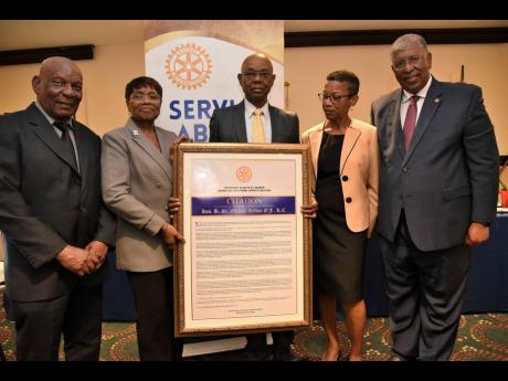 Jemelia Davis (second left), president of the Rotary Club of St Andrew, presents a citation to Michael Hylton (centre) as he receives the Orville Walker Vocational Service Award. Sharing in the occasion are (from left) the Reverend Dr Webster Edwards, past