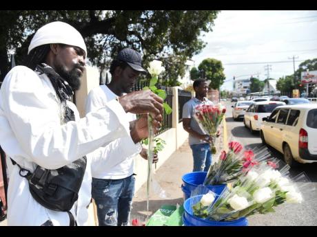 Shamar Green (left), Ricardo Rowe (centre) and Santana Spencer (right) prepare and sell roses along Waterloo Road in St Andrew on Valentine’s Day. See more from Valentine’s Day on Page A2.