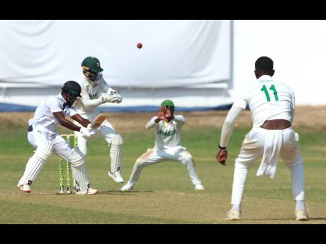 CCC batsman Jonathan Carter (left) cuts off-spinner Peat Salmon (right) for runs during their West Indies Championship match against the Jamaica Scorpions at Sabina Park yesterday. Looking on are wicket-keeper Romaine Morris (second left) and captain Jerma