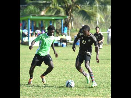 Montego Bay United’s (MBU) Garcian Allen (left) attempts to stop the dribble of Reggae Boy invite Kaheim Dixon during a practice match at Wespow Park in Montego Bay yesterday.