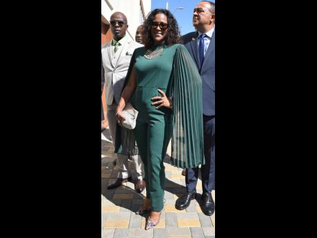 Flanked by fellow party members, Senator Saphire Longmore struck a pose to show off this emerald green cape-sleeve jumpsuit.  
