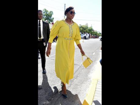 Stunning in this sunshine-yellow dress and matching bag, Speaker of the House Juliet Holness is serious as she struts to Gordon House.  