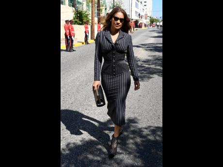 With her Fendi First Medium leather bag in hand, Member of Parliament Lisa Hanna struts in her pinstripe suit-dress paired with a sheer underbust corset.