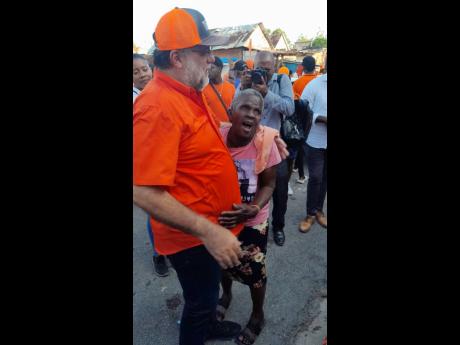 Pamella Millard hugs PNP President Mark Golding for the first time during the tour. 