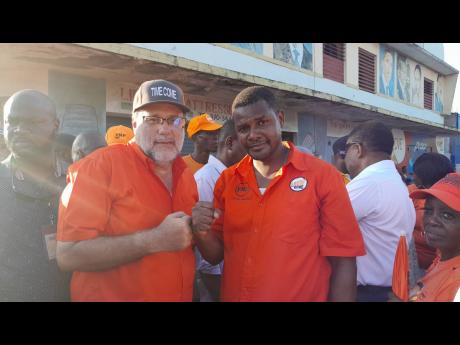 Mark Golding (left), president of the People’s National Party, with Shawn McGregor, candidate for the Rae Town division in Central Kingston, during a PNP tour in the community on Thursday. 