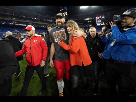 Kansas City Chiefs tight end Travis Kelce walks with Taylor Swift following the AFC Championship NFL football game between the Baltimore Ravens and the Kansas City Chiefs in Baltimore on January 28.