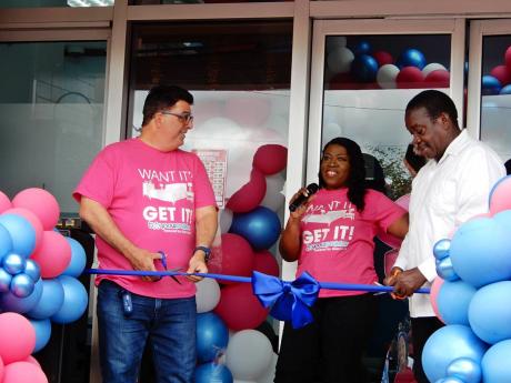 Cool Corp chairman, Joseph Issa (left) and Robert Montague (right), member of parliament, Western St Mary, wait on Coolmarket general manager, Viviene Reynolds, to give the go-ahead to cut the ribbon to officially open the new Coolmarket Store in Ocho Rios