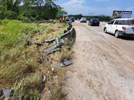 A damaged section of the guardrail along the intersection of the Daniel Town main road and the North Coast Highway in Trelawny, where a Toyota Mark X motorcar collided with an Audi Q3 motorcar early Sunday morning. Four men who were in the Mark X died as a