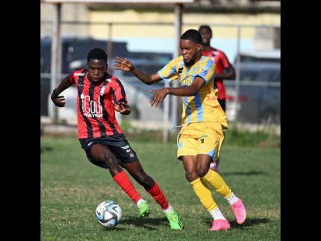 Kaheim Dixon (left) of Arnett Gardens moves away from Waterhouse’s Leonardo Jebbison during yesterday’s Jamaica Premier League match at the Drewsland Mini-Stadium. The game ended in a 0-0 draw.