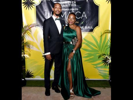 DuWayne O’Reggio stands beside his wife O’Neisha, who is dressed in an emerald-green gown with a thigh-high slit.