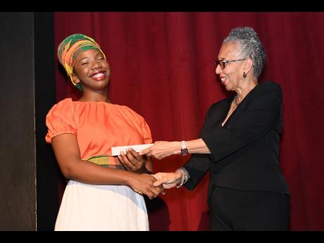 UWI International Relations student Deanna Fraser is delighted to receive the Rex Nettleford Hall Award of excellence during the Remembering Rex celebration.