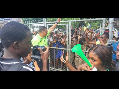 Prime Minister Andrew Holness greeting students of Buff Bay Primary during a tour of West Portland on Monday.