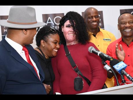 Alecia King (centre) is hugged by her stepmother, Julia Mendez, in a joyous moment at an event to give an update on her recovery on Tuesday. Sharing in the moment with them are (from left) Stephen Joseph, project manager at the Sanmerna Foundation, and Dir