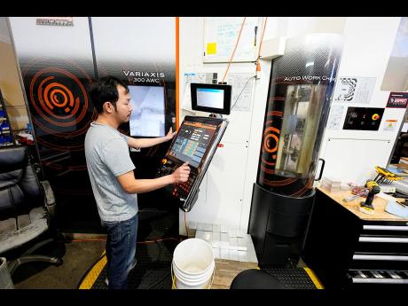 A worker at Reata Engineering and Machine Works programmes a Mazak Variaxis machine used to make semiconductor pieces on Thursday, February 15, in Englewood, Colorado. Reata, which supplies the aviation and medical device industries, has invested heavily i