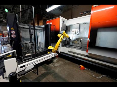 
A Halter robot collects a finished piece for blood pressure pumps from a Mazak Integrex at Reata Engineering and Machine Works on Thursday, February 15, in Englewood, Colorado. Reata, which supplies the aviation and medical device industries, has invested