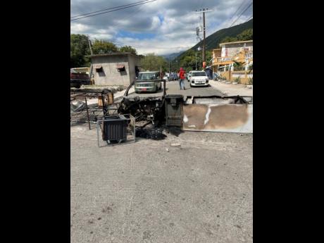 Debris blocks August Town Road in St Andrew after a fiery protest.