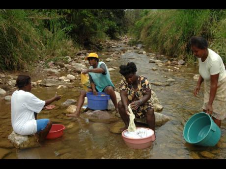 Residents from Freeman’s Hall on one of their weekly washdays at the Quashie River in Trelawny.