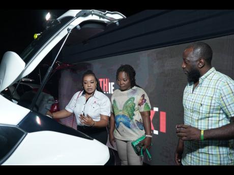 Suzuki Sales Executive Jheanelle Parker (left) expertly guides Latoya Wright (centre) and Michael Diamond (right) through the impressive features of the Suzuki Fronx.