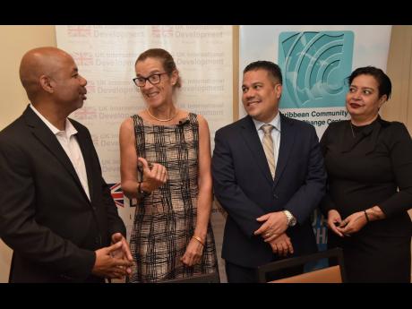 Dr Colin Young (left), executive director of the Caribbean Community Climate Change Centre (CCCCC), talks about climate change with Judith Slater (second left), British High Commissioner to Jamaica, Senator Matthew Samuda, minister without portfolio in the