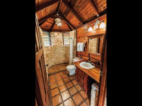 A unique cutstone and wood finished bathroom.