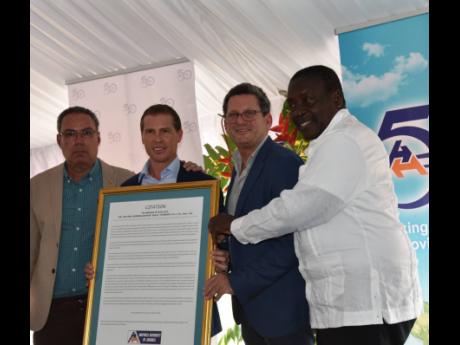 Executive Chairman of Sandals Resorts International, Adam Stewart (second left), accepts a special citation from the Airports Authority of Jamaica on behalf of his late father Gordon 'Butch' Stewart. Also pictured from left are Minister of Transport, Daryl
