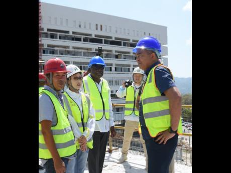 Health Minister Dr Christopher Tufton (right) during a tour of the Cornwall Regional Hospital in St James last year, where he discussed the ongoing restoration project with (from left) Qiu Ye Bo, Fiona Wang, and Conrad Pitkin, custos of St James.