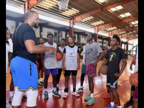 Jamaican basketballer Samardo Samuels (left) talks to the P.H.A.S.E 1  Academy players during a training session at the Montego Bay Community College in St James last Saturday. 