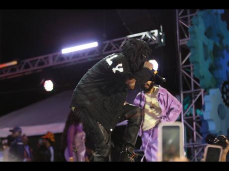 Cloaked in all black, Popcaan was almost unrecognisable, save for the word UNRULY emblazoned in large letters across his back and his trademark 876 GUD chain. 