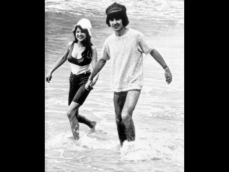 George Harrison, of the Beatles singing group, splashes in the surf with his bride, former model Pattie Boyd, February 12, 1966. Love letters to Pattie Boyd from both George Harrison and Eric Clapton are going up for sale at Christie’s auction house, alo