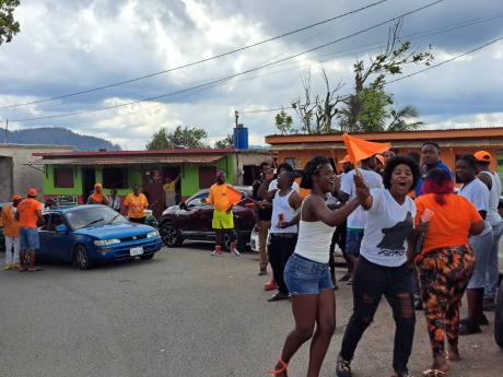 Residents of Allside in Wait-a-bit, Trelawny, wave orange flags in support of the People’s National Party (PNP), moments after declaring they would be switching their support away from the Jamaica Labour Party.