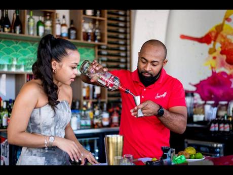 A mini mixology class was in session as social media influencer Georgia Bayley (left) was guided by Mixologist Andrew Campbell on the measurements needed to create the Smirnoff Sensation.