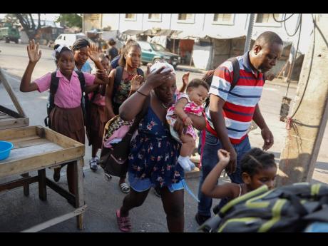 Residents flee their homes during clashes between police and gang member at the Portail neighborhood in Port-au-Prince, Haiti on Thursday. 