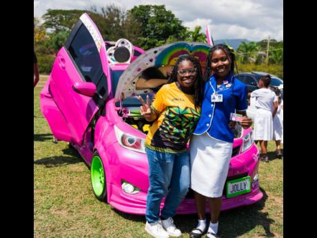 A fully customized pink Toyota Vitz serves as the perfect backdrop for these students.