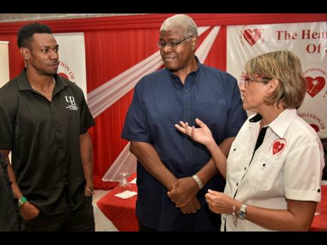 Debra Chen (right), executive director, The Heart Foundation of Jamaica, talks about having a healthy heart with Olympian Yohan Blake (left) and Dr Garth Rattray, general family practitioner, during the launch of Heart Month at the Terra Nova hotel in King
