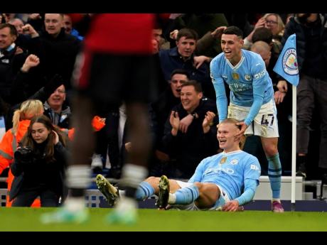 Manchester City’s Erling Haaland celebrates with Phil Foden (right) after scoring his side’s third goal during an English Premier League match between Manchester City and Manchester United at the Etihad Stadium in Manchester, England yesterday.