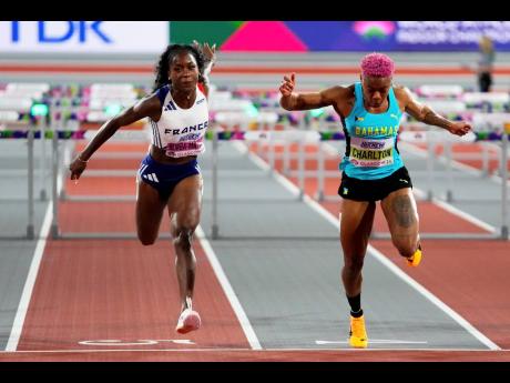 Devynne Charlton (right)  of The Bahamas crosses the finish line to win the gold medal in the 60-metre hurdles ahead of second-place Cyrena Samba-Mayela, of France at the World Athletics Indoor Championships in Glasgow, Scotland, yesterday. Charlton won th