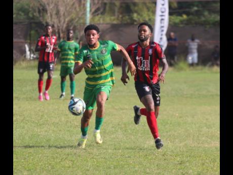 Arnett Gardens’ goal-scorer Roderick Granville (right) is in a race for the ball with Vere United’s Odane Murray during their Jamaica Premier League encounter at Effortville Community yesterday. 