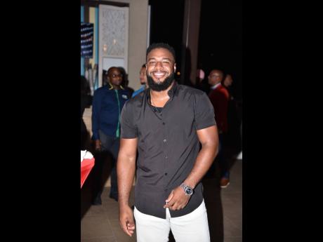 Social media personality and content creator Andre Skeen flashes a pearly white smile in a classic button-down shirt and jeans combo.