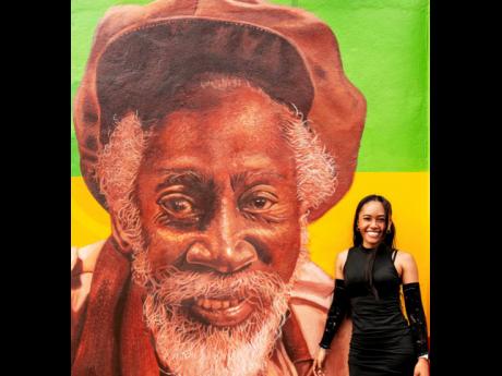 The super talented artist, Pamella Chang, stands proudly beside her painting of Bunny Wailer as part of the One Love Mural in Trench Town. 