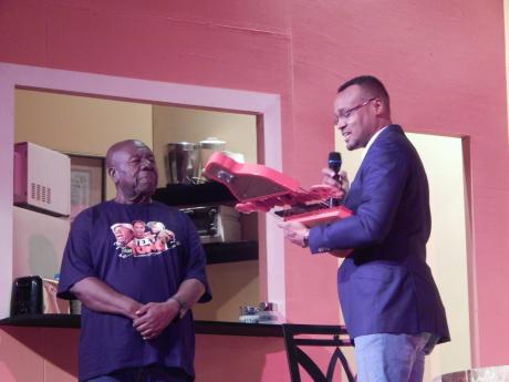 Oliver Samuels (left) receiving his Red Stripe Living Legend award from Brand Manager Nathan Nelms at the Little Theatre on Friday night. 