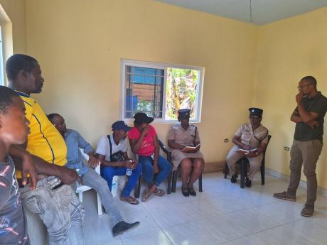 Police officers from the Westmoreland Police Division meeting with relatives of the two teenage boys who were allegedly killed during a police high speed chase in Westmoreland on Friday. 