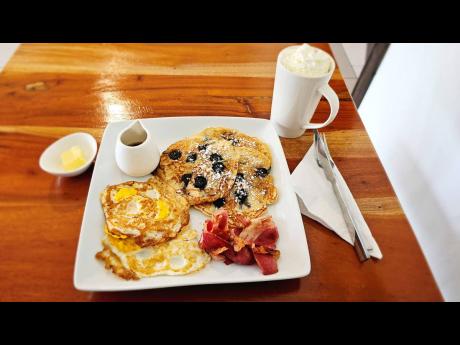 Indulge in all-day breakfast featuring scrumptious blueberry pancakes, fried eggs, crispy bacon, and heart-warming hot chocolate.