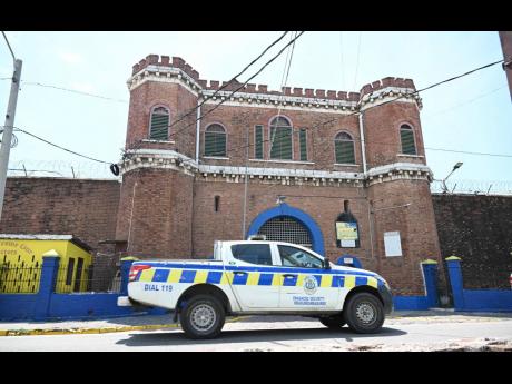 A police patrol car passes the Tower Street Adult Correctional Centre in downtown Kingston, yesterday. Dancehall artiste Vybz Kartel has been housed at the facility since his murder conviction in 2014. 